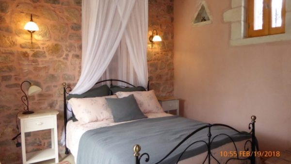 Comfortable bedroom featuring exposed stone walls